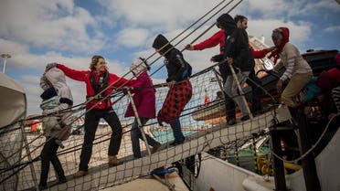 aid workers from the Spanish NGO Proactiva Open Arms help refugees and migrants to disembark from the rescue vessel, at the port of Pozzallo, in Sicily, Italy. (AP)