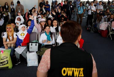 Filipino workers who were repatriated from Kuwait take part in a dialogue with a Department of Labour official in Paranaque. (Reuters)