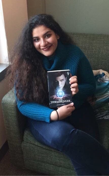 Teenaged author Rachita Mishra holds a copy of her book, The Stormbringer. (Supplied)