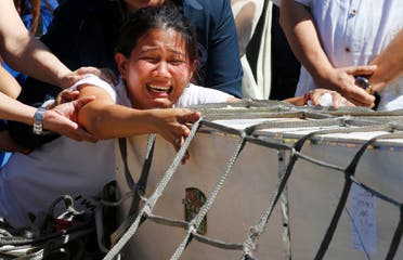 Jessica Demafelis, the sister of Joanna Demafelis who was found dead in a freezer in Kuwait, cries as the wooden casket of her remains arrives at the Ninoy Aquino International Airport Friday, Feb. 16, 2018