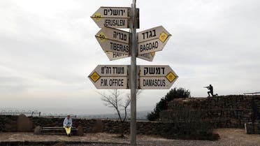 A woman sits near a sign at Mount Bental, an observation post in the Israeli-occupied Golan Heights that overlooks the Syrian side of the Quneitra crossing, Israel February 10, 2018. (Reuters)