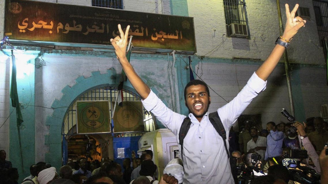 Family members shout slogans as they wait outside the Kobar prison in north Khartoum to welcome their loved ones. (AFP)