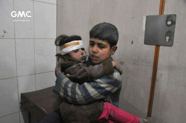 Two Syrian kids who were wounded during airstrikes and shelling by Syrian government forces, sit at a makeshift hospital in Ghouta. (AP)