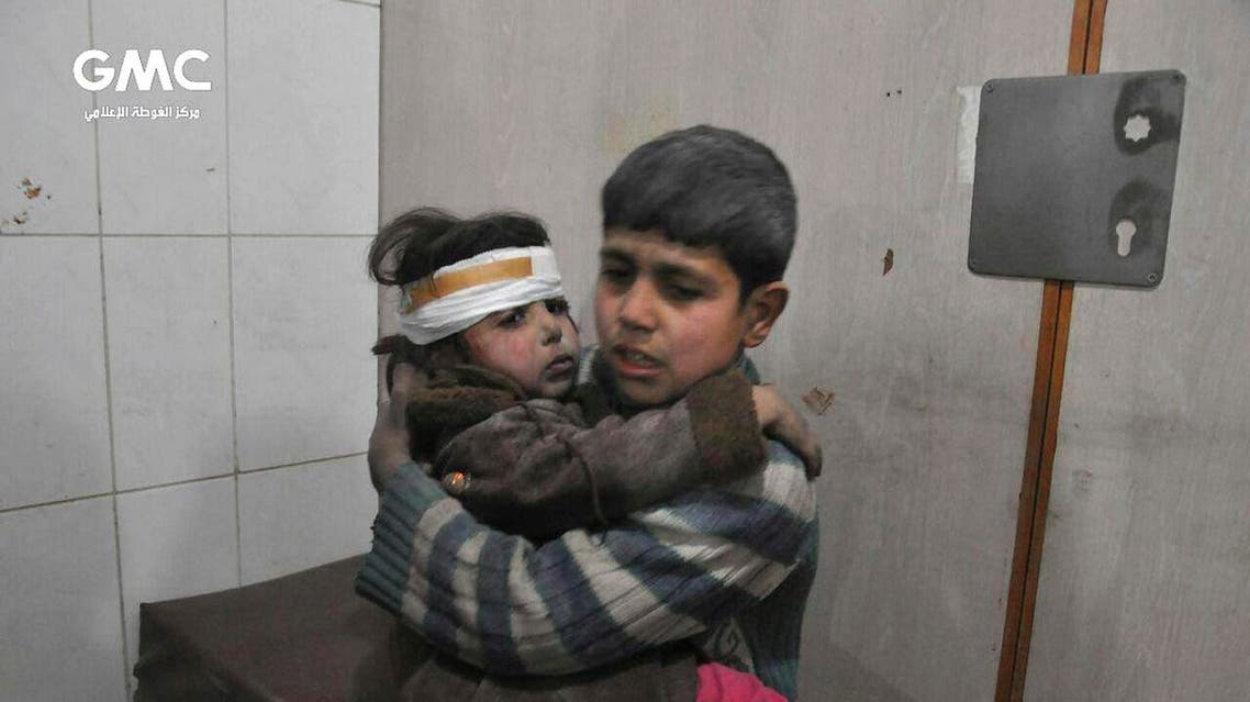 Two Syrian kids who were wounded during airstrikes and shelling by Syrian government forces, sit at a makeshift hospital in Ghouta. (AP)