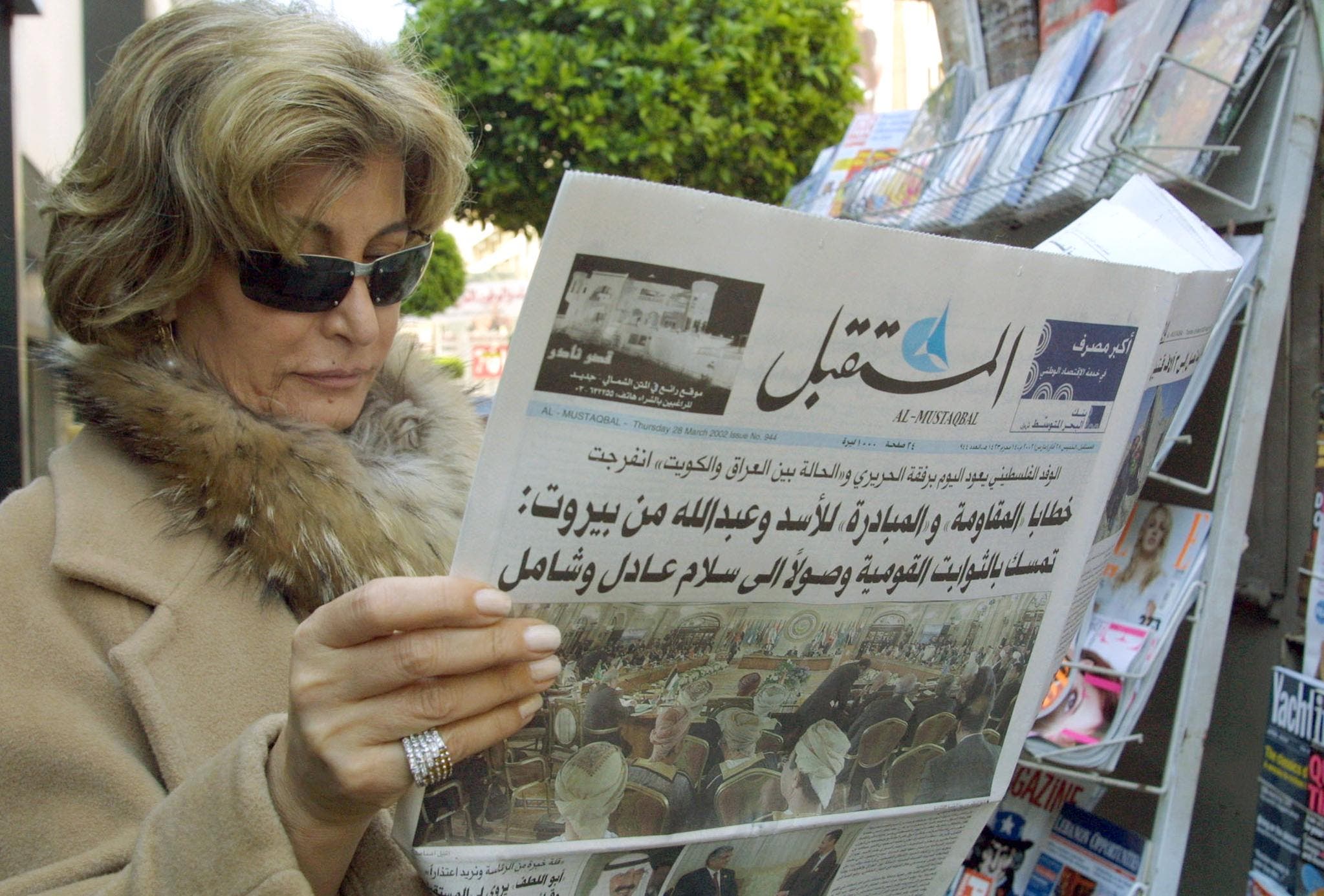 لبنانية تقرأ صحيفة عقب القمة العربية في بيروت 2002