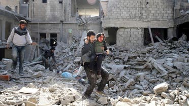 ATTENTION EDITORS - VISUAL COVERAGE OF SCENES OF INJURY OR DEATH A man carries an injured boy as he walks on rubble of damaged buildings in the rebel held besieged town of Hamouriyeh, eastern Ghouta, near Damascus, Syria February 21, 2018. REUTERS/Bassam Khabieh TEMPLATE OUT TPX IMAGES OF THE DAY