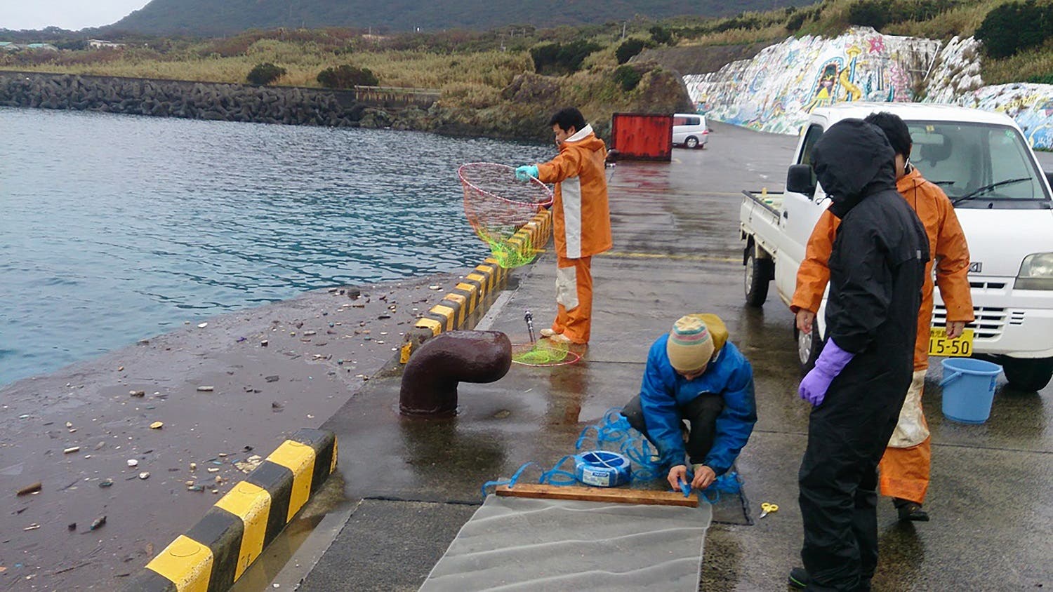 This handout picture taken on January 28, 2018 shows an oil-like substance drifting in a quay in Toshima village at Takarajima island, Kagoshima prefecture. (AFP)