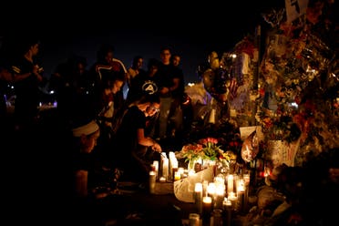 People light candles in front of mementoes placed in front of the fence of the Marjory Stoneman Douglas High School to commemorate the victims of the mass shooting, in Parkland, Florida, U.S., February 21, 2018. (Reuters)