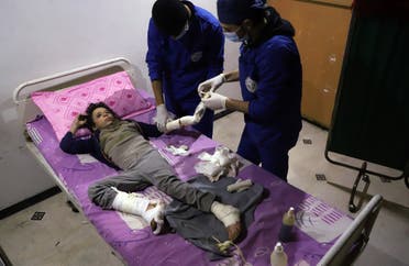 Doctors treat ten-year-old Omar who was injured in an air strike that killed several members of his family on their home in Otaybah, at a make-shift hospital in Syria's rebel-held enclave of Eastern Ghouta, on February 25, 2018.  AMER ALMOHIBANY / AFP