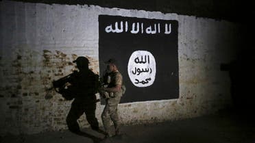 An Iraqi soldier inspects a recently-discovered train tunnel, adorned with an ISIS group flag. (File photo: AP)