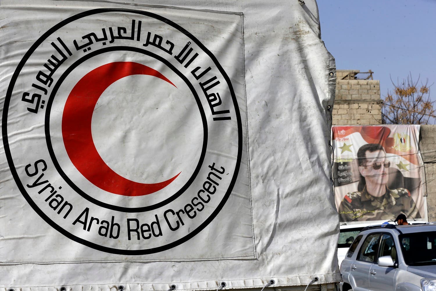 Syrian Arab Red Crescent vehicles carrying aid wait at a checkpoint on the outskirts of Damascus before delivering aid to the rebel-held enclave on March 5, 2018. (AFP)