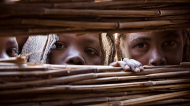 Refugees who fled the conflict in Sudan's western Darfur region peek through a hole in a shelter to watch a circumcision ceremony at Djabal camp near Gos Beida in eastern Chad June 19, 2008. (Reuters)