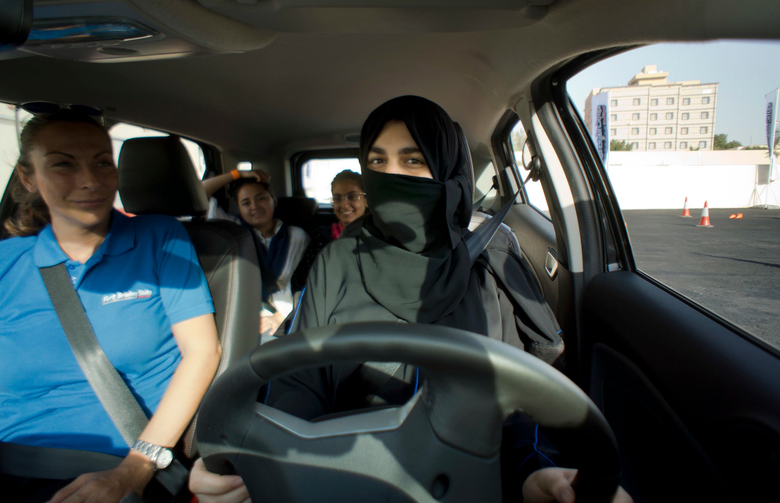Razan, right, sits for the first time in the driver's seat, with her trainer Francesca Pardini, an Italian ex-race car driver, during training sponsored by Ford Motor, in Jiddah, Saudi Arabia, Tuesday, March 6, 2018. (AP
