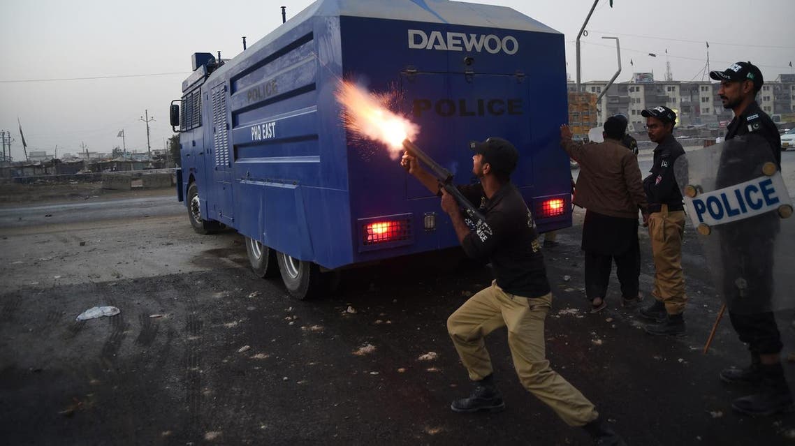 A Pakistani policeman fires a teargas shell towards demonstrators during a protest. (AFP)