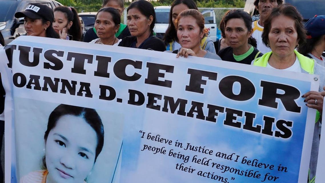 Residents display placards as they wait for the arrival of the body of Joanna Demafelis, a Filipina domestic helper who was killed and found inside a freezer in Kuwait, in her hometown in Iloilo. (Reuters)