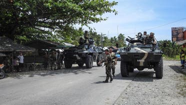 Philippine soldiers standing next to their armored personnel carriers as they man a checkpoint along a highway near the clash site between government troops and militants in Datu Saudi Ampatuan town, Maguindanao province. (AFP)