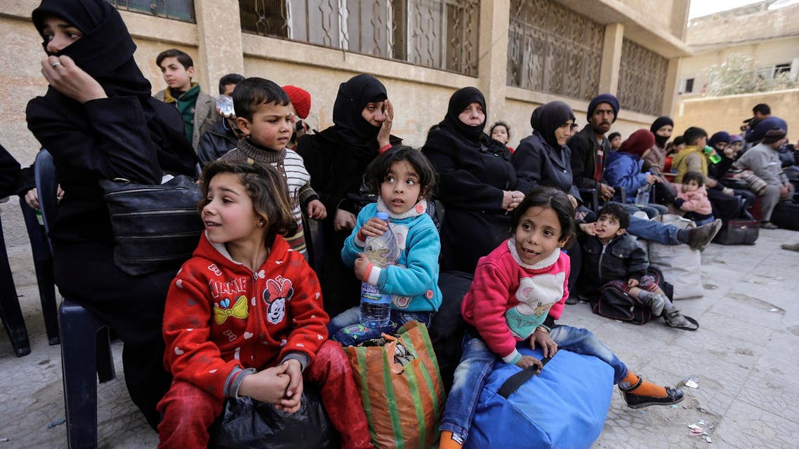 Women carrying infants waited at a school near the al-Wafideen crossing. (File photo: AFP)