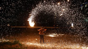 An Iranian man plays with a firework during Chaharshanbe Souri in Tehran on March 17, 2015. (AP)