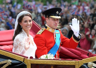 Britain's Prince William and his wife Kate, Duchess of Cambridge, wave as they travel in the 1902 State Landau carriage along the Processional Route to Buckingham Palace, in London, on April 29, 2011. (AFP)