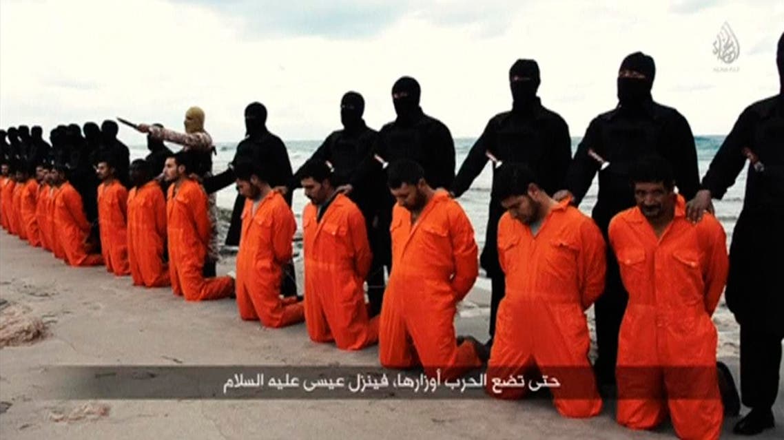 Men in orange jumpsuits purported to be Egyptian Christians held captive by the Islamic State (IS) kneel in front of armed men along a beach said to be near Tripoli. (File photo: Reuters/Social media)