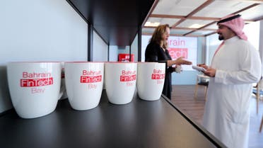 Coffee mugs with logos of Bahrain FinTech Bay on display as staff chat in its office in Bahrain Bay on February 28, 2018. (Reuters)
