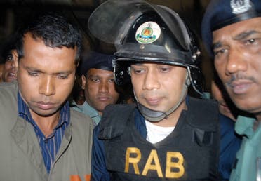 Bangladeshi policemen escort Tarique Rahman to court in Dhaka on 08 March 2007. (AFP)