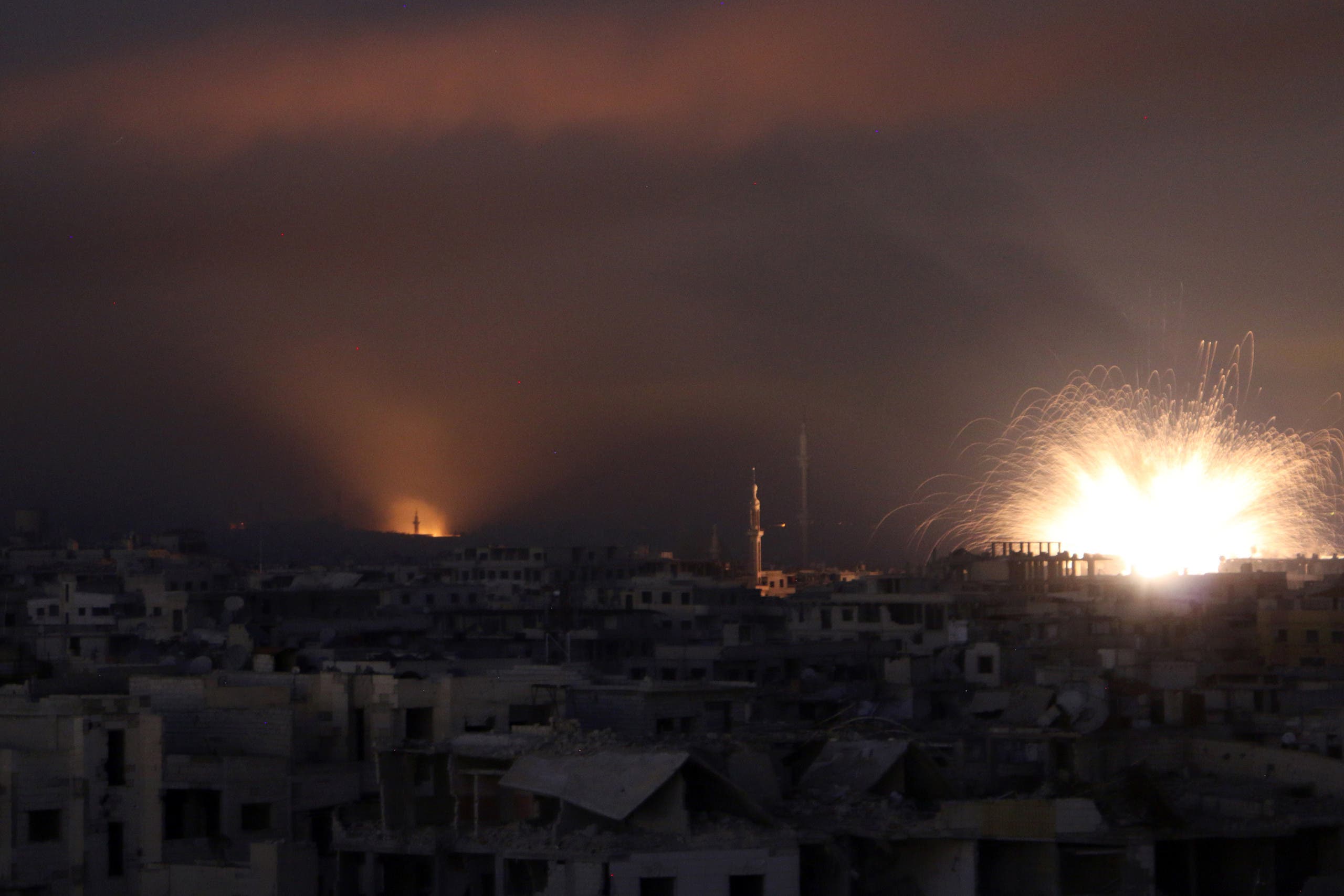 A general view shows explosions lighting the sky following regime air strikes on Zamalka, in the rebel enclave of Eastern Ghouta on the outskirts of Damascus on March 12, 2018. (AFP)