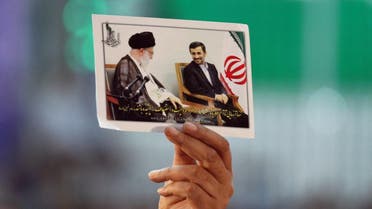 An Iranian man holds portraits of President Mahmoud Ahmadinejad (R) and supreme leader, Ayatollah Ali Khamenei. (File photo: AFP)