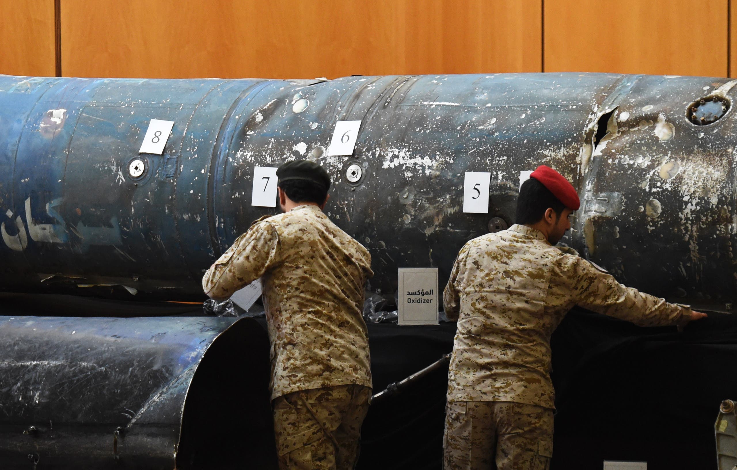 Saudi soldiers reveal the remains of missiles, that a military coalition led by Saudi Arabia claim are Iranian during a press conference at the Armed Forces club in Riyadh on March 26, 2018. A military coalition led by Saudi Arabia threatened retaliation against Iran, accusing the Shiite power of being behind multiple Yemeni rebel missile attacks on the kingdom. FAYEZ NURELDINE / AFP