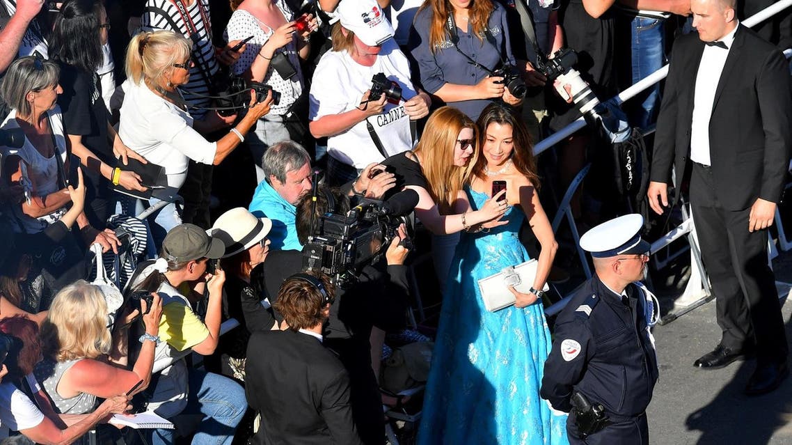 Actress Michelle Yeoh poses for selfies as she arrives for the screening of the film ‘Ismael's Ghosts’ during the opening ceremony of the 70th edition of the Cannes Film Festival in Cannes, southern France. (AFP)