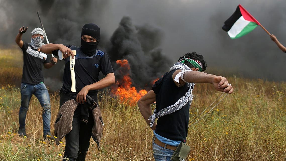 A Palestinian demonstrator holds an axe during clashes with Israeli troops, during a tent city protest along the Israel border with Gaza, demanding the right to return to their homeland, on March 30, 2018. (Reuters)