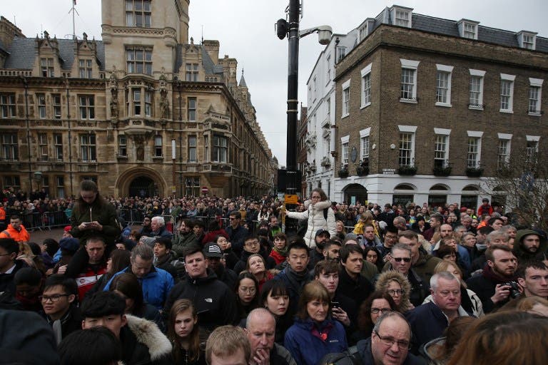 People wait for guests to arrive for the funeral of British scientist Stephen Hawking at the Church of St Mary the Great, in Cambridge on March 31, 2018. Friends, family and colleagues of British scientist Stephen Hawking gathered to pay their respects at his private funeral in Cambridge, where he spent most of his extraordinary life. Daniel LEAL-OLIVAS / AFP