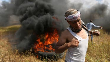 Palestinian runs during clashes with Israeli troops, during a tent city protest along the Israel border. (Reuters)