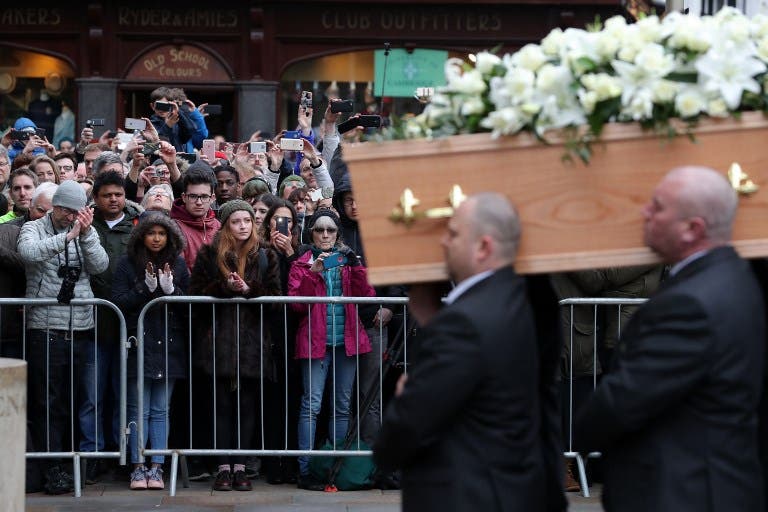 People applaud as Stephen Hawking's coffin is carried into the church by six porters from the Gonville and Caius College at the Church of St Mary the Great, in Cambridge on March 31, 2018. Friends, family and colleagues of British scientist Stephen Hawking gathered to pay their respects at his private funeral in Cambridge, where he spent most of his extraordinary life. Daniel LEAL-OLIVAS / AFP