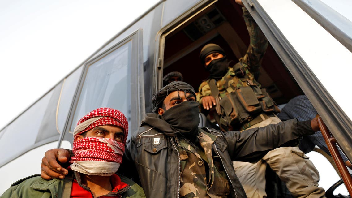 Rebel fighters gesture as they stand next to a bus before their evacuation, at Harasta highway outside Jobar, in Damascus, Syria March 26, 2018. REUTERS/Omar Sanadiki