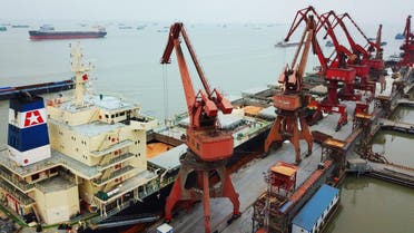 This aerial view shows workers loading imported soybeans from cargo ships at a port in Nantong in China's eastern Jiangsu province on April 4, 2018. China unveiled plans on April 4 to hit major US exports worth $50 billion such as soybeans, cars and small airplanes with retaliatory tariffs in an escalating trade duel between the world's two top economies. (AFP)