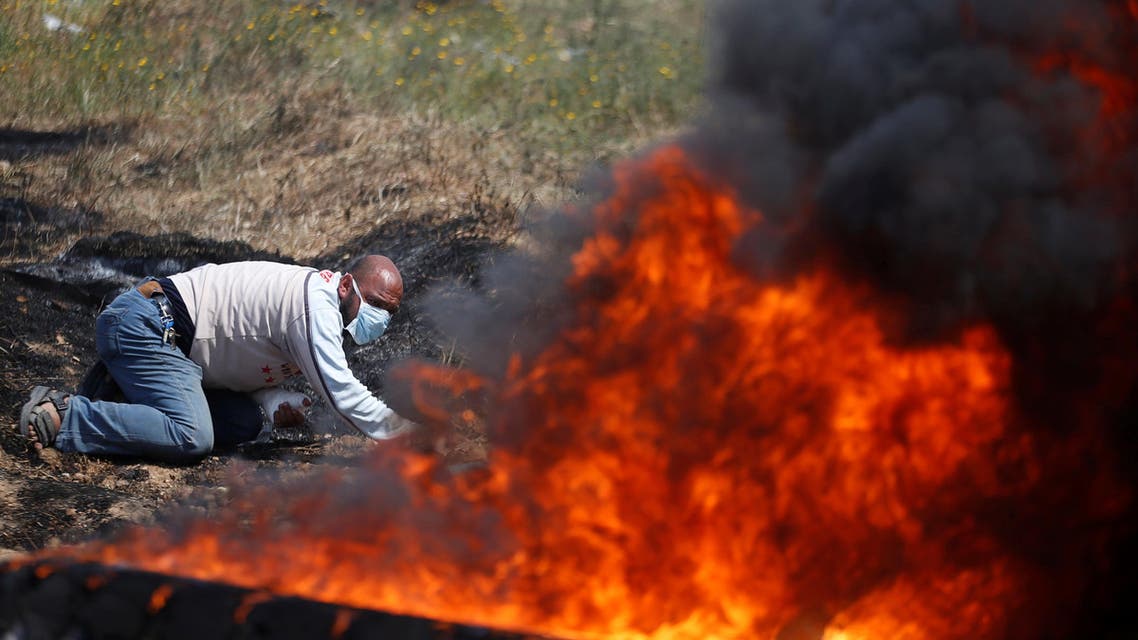 A Palestinian takes cover during clashes with Israeli troops at a protest demanding the right to return to their homeland, at the Israel-Gaza border east of Gaza City April 6, 2018. REUTERS/Mohammed Salem