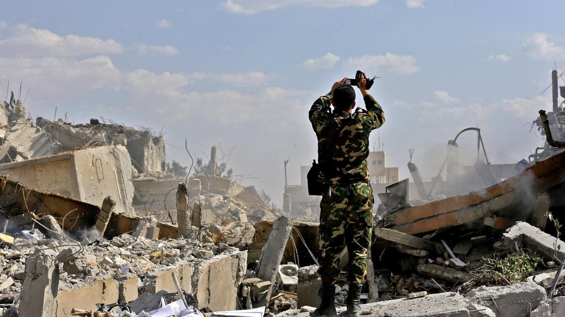 A Syrian soldier inspects the wreckage of a building in the Barzeh district, north of Damascus, on April 14, 2018. (AFP)