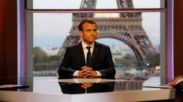 French President Emmanuel Macron poses on the TV set before an interview with RMC-BFM and Mediapart French journalists. (Reuters)