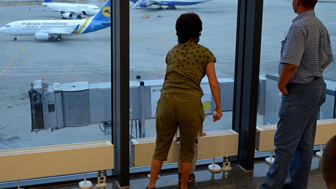 Passengers look in the window as they rest in the transit zone in Sheremetyevo airport terminal F in Moscow. (AFP)