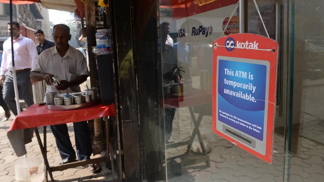 a sign stating the at the ATM is unavailable is hung onto the door of an ATM in Mumbai. (AFP)