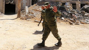 Russian forces walk past damaged buildings in Douma during an organized media tour on April 16, 2018. (AFP)