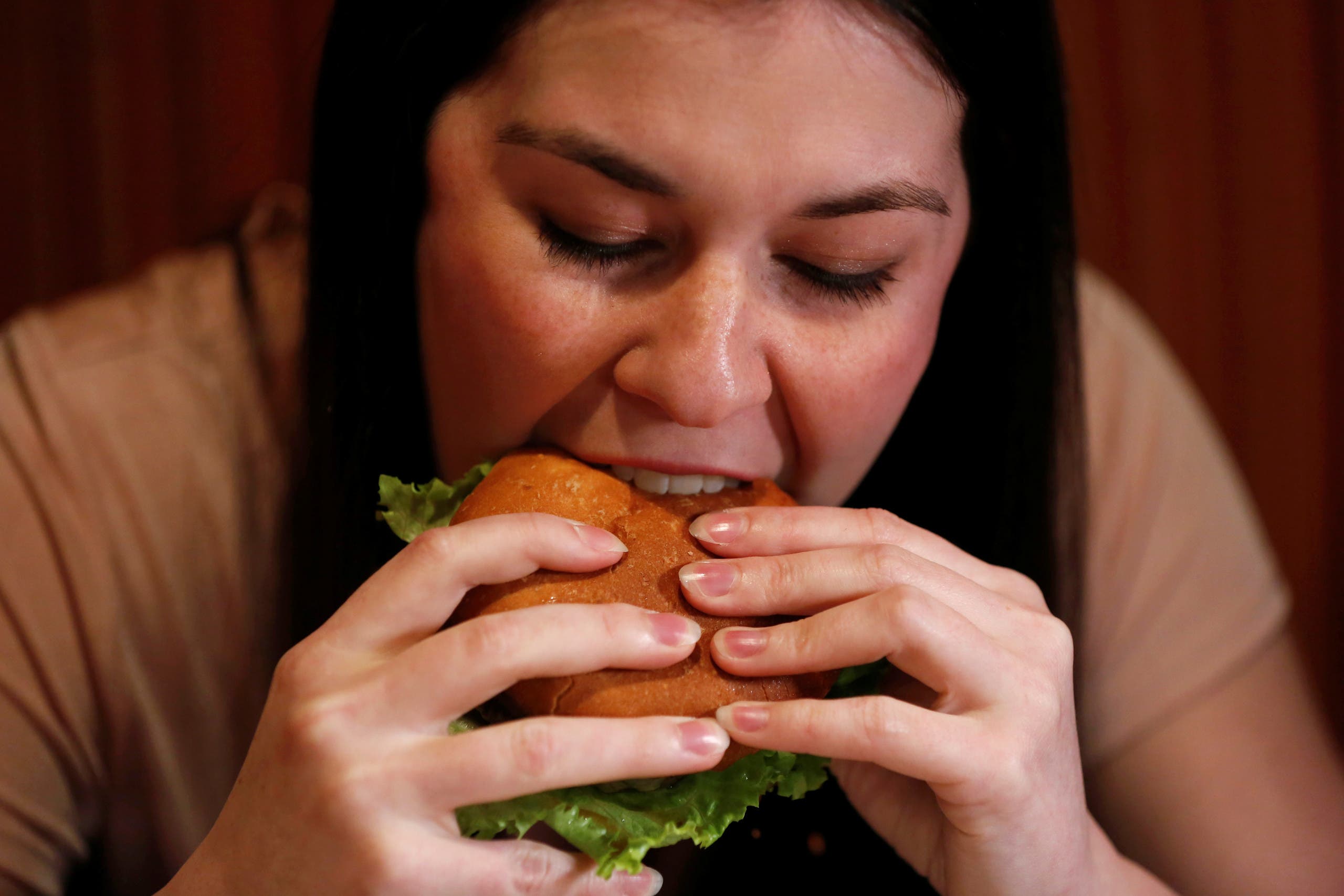 Kristin Barnaby eats a burger prepared with a tarantula at Bull City Burger and Brewery in celebration of Exotic Meat Month in Durham, North Carolina, U.S. April 16, 2018. Picture taken April 16, 2018. REUTERS/Jim Urquhart