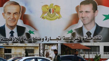 A billboard sponsored by Latakia's chamber of commerce and industry shows pictures of Syrian President Bashar al-Assad (R) and his late father former president Hafez al-Assad in the coastal city of Latakia. (AFP)