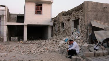 An Iranian man squats next to his destroyed house in the town of Shonbeh, southeast of Bushehr, on April 9, 2013 after a powerful earthquake struck near the Gulf port city of Bushehr. The 6.1 magnitude quake killed at least 30 people and injured 800 but Iran's only nuclear power plant was left intact, officials said. AFP PHOTO/FARS NEWS/MOHAMMAD FATEMI