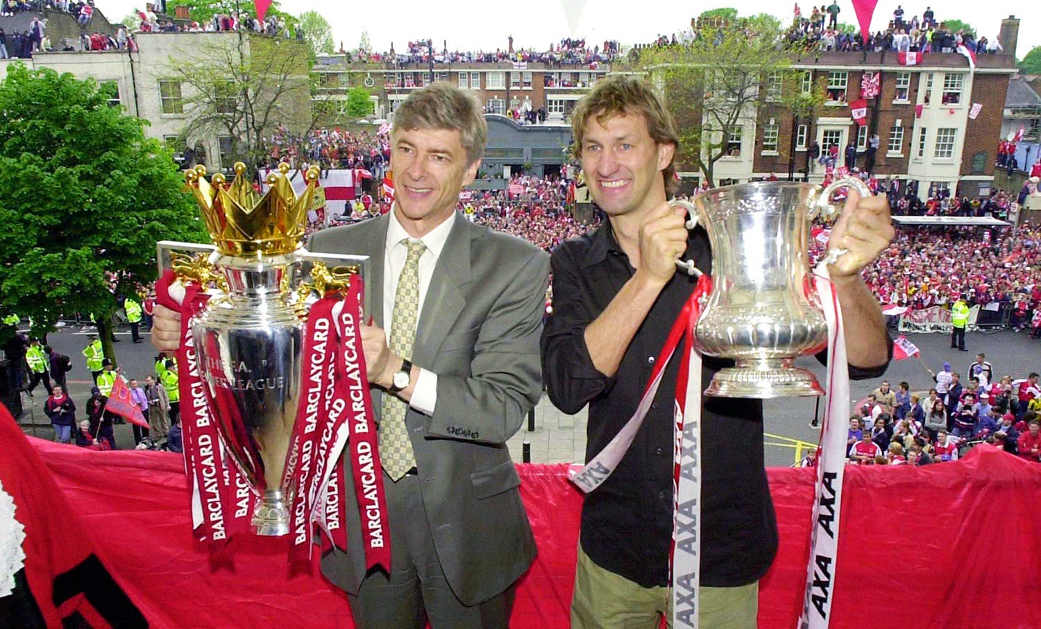 In this May 12, 2002 file photo Arsenal’s manager Arsene Wenger, left, and captain Tony Adams proudly hold the Premier League Trophy and FA Cup. (AP)