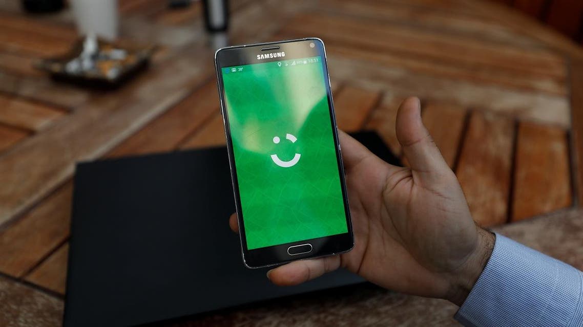 An employee shows the logo of ride-hailing company Careem on his mobile in his office in the West Bank city of Ramallah July 17, 2017. (Reuters)