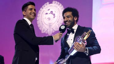 Liverpool soccer player Mohamed Salah, right, is presented with the PFA Player Of The Year Award Trophy. (Reuters)