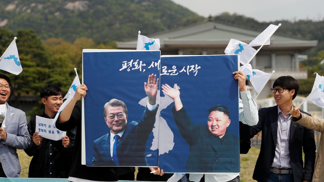 Students hold posters with pictures of South Korea's President Moon Jae-in and North Korea's leader Kim Jong Un during a pro-unification rally ahead of the upcoming summit between North and South Korea in Seoul, South Korea April 26, 2018. REUTERS/Jorge Silva
