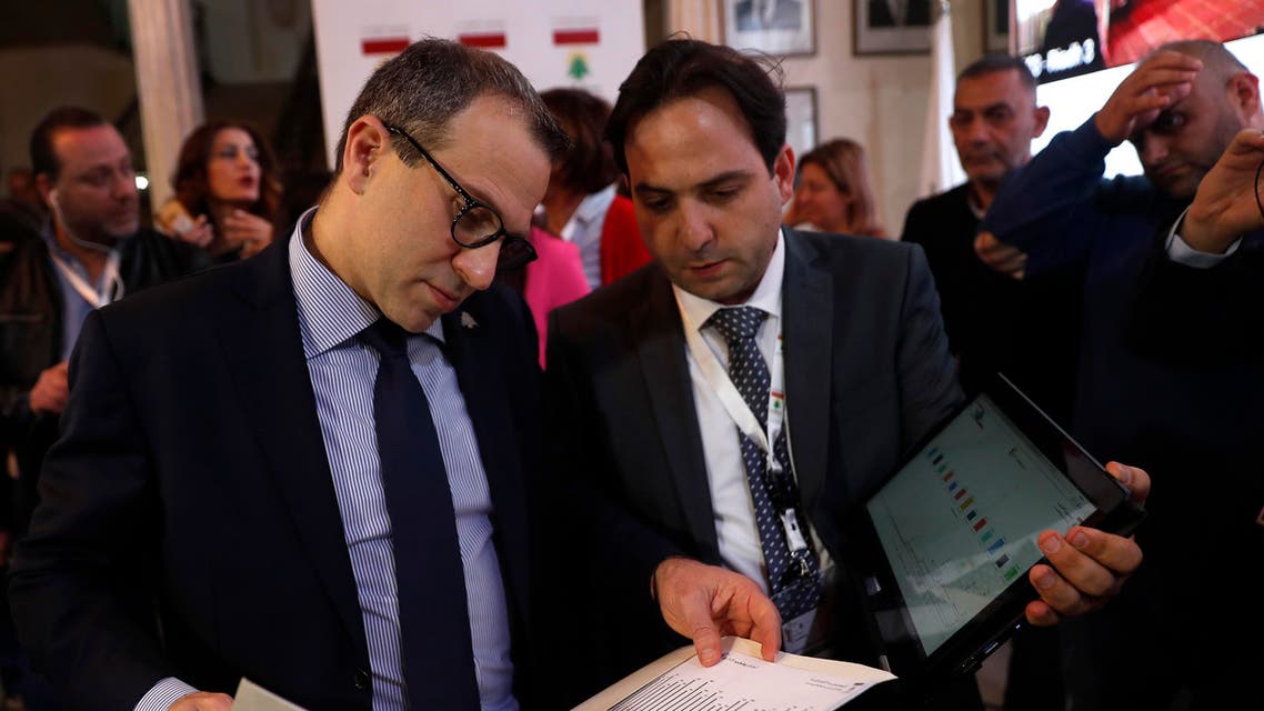 Lebanese Foreign Minister Gibran Bassil, left, follows the latest voting results by Lebanese expatriates in six Arab countries, ahead of parliamentary elections scheduled to be held in Lebanon on May 6, at the Lebanese Foreign Ministry in Beirut, Friday, April 27, 2018. The elections are the first in nine years, and the voting abroad marks the first time that expatriates are allowed to participate in parliamentary elections in Lebanon. (AP Photo/Hussein Malla)